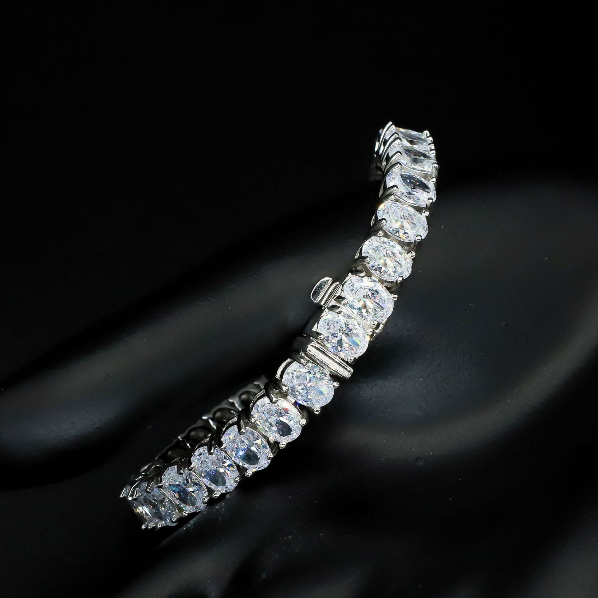 A 925 sterling silver tennis bracelet featuring egg-shaped zircon stones. This elegant bracelet showcases a series of sparkling zircon gems set in polished silver, with a delicate yet secure clasp. Perfect for adding a touch of sophistication and glamour to both casual and formal outfits, offering a timeless and luxurious accessory