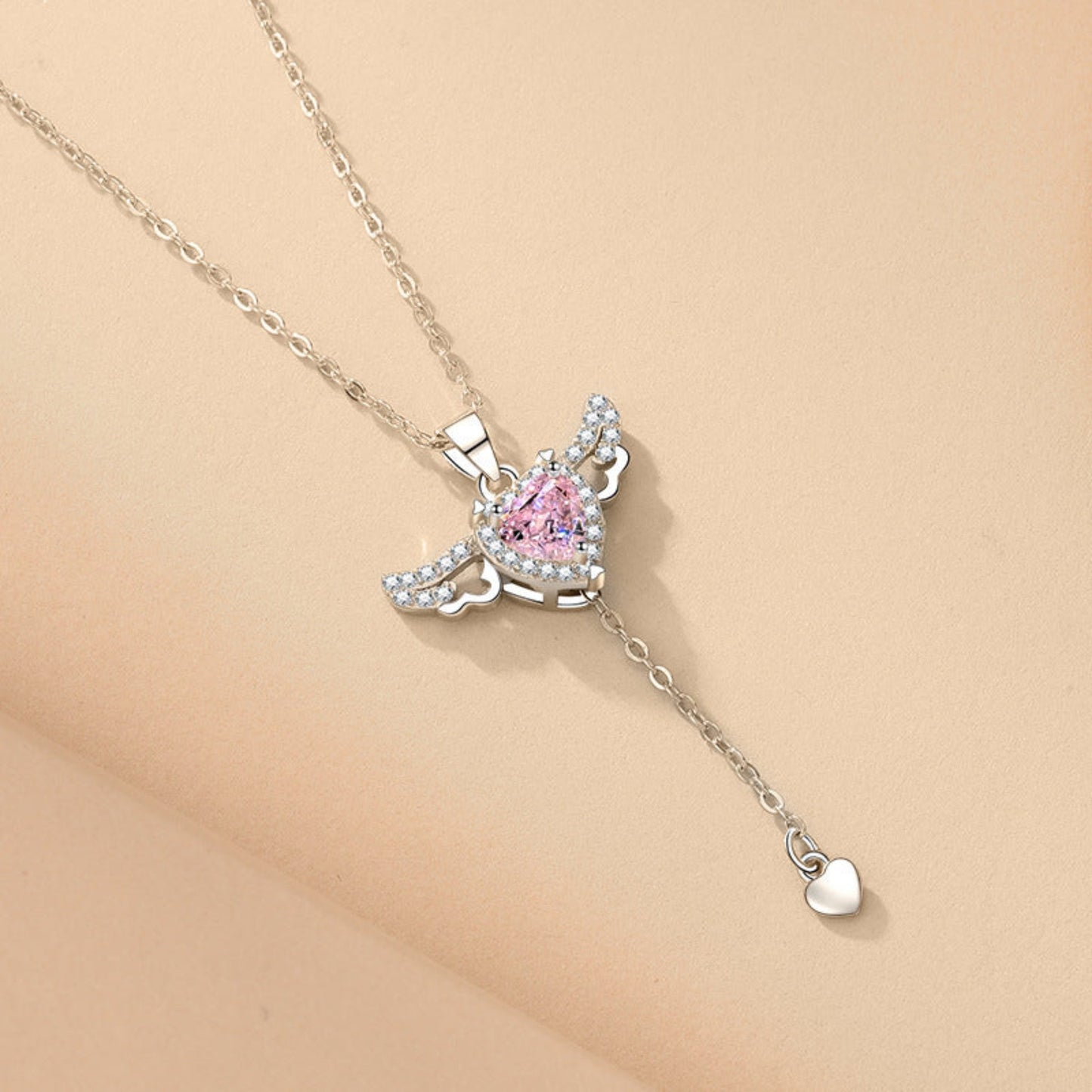  Delicate Cupid-inspired necklace featuring a heart charm with wings and elegant tassels, creating a romantic and whimsical look. Perfect for adding a touch of charm and personality to any outfit.