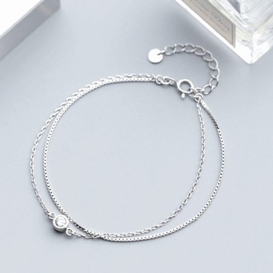 Stunning double-layer silver bracelet adorned with shimmering diamonds. This elegant piece offers a modern yet timeless design, perfect for adding a touch of glamour to any outfit.