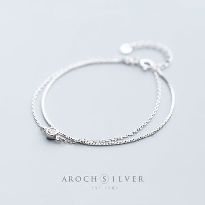 Stunning double-layer silver bracelet adorned with shimmering diamonds. This elegant piece offers a modern yet timeless design, perfect for adding a touch of glamour to any outfit.