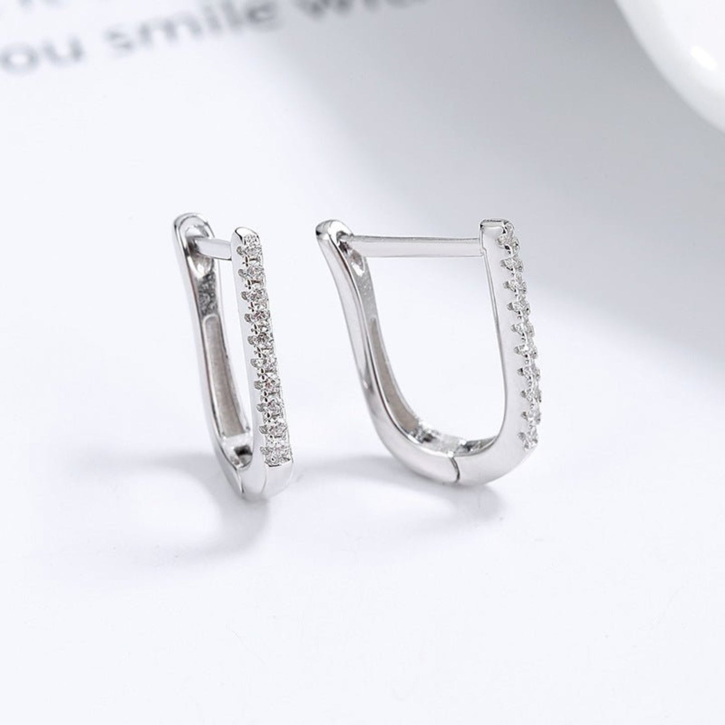 A pair of 925 silver geometric U-shaped earrings with a minimalist and modern design. These earrings feature a sleek U-shaped curve with a polished silver finish, offering a subtle yet elegant look. Ideal for both casual and formal outfits, these lightweight earrings provide a stylish and versatile accessory option