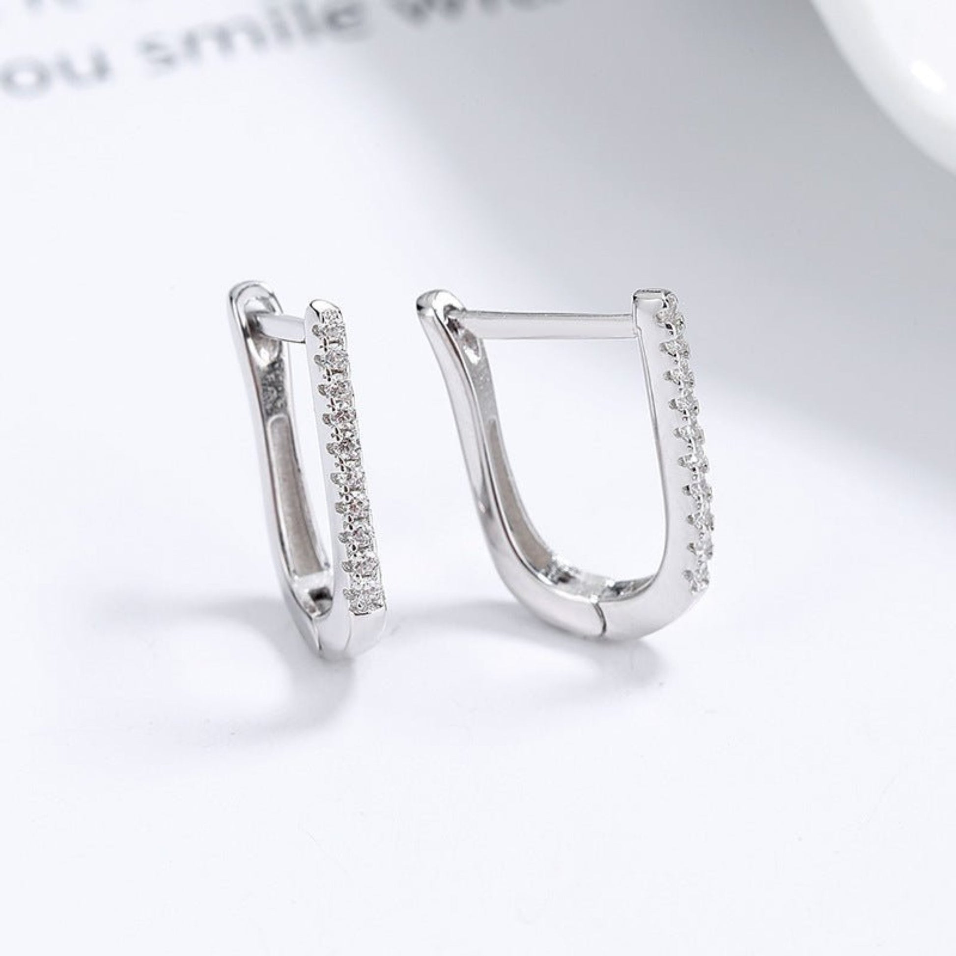 A pair of 925 silver geometric U-shaped earrings with a minimalist and modern design. These earrings feature a sleek U-shaped curve with a polished silver finish, offering a subtle yet elegant look. Ideal for both casual and formal outfits, these lightweight earrings provide a stylish and versatile accessory option